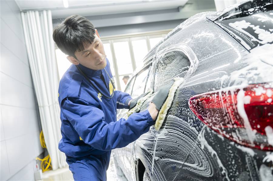 泡を立てて手洗い洗車をするスタッフ